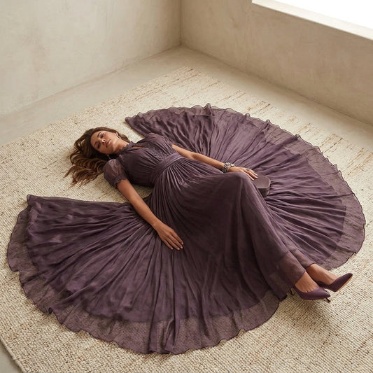 Model lying down in purple chiffon lace maxi dress with skirt fanned out