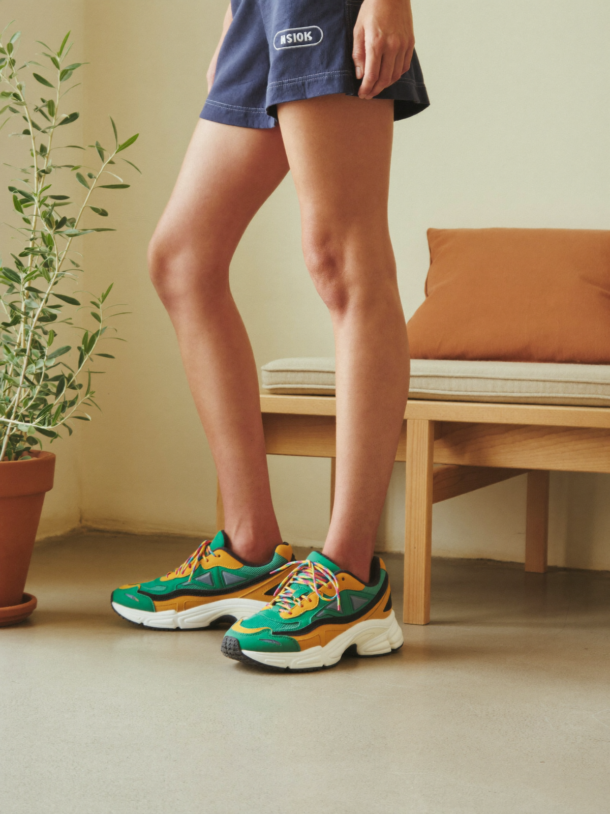 Model wearing green rainbow colorblock chunky sneakers