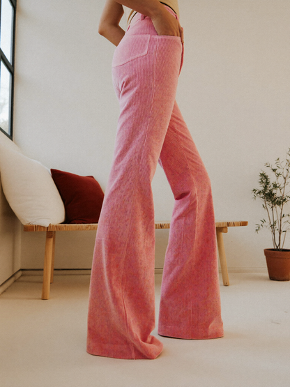 Model wearing pink flared trousers, posing