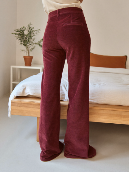 Model wearing burgundy flared trousers, lifestyle