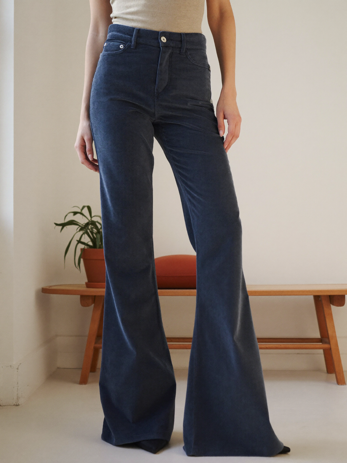 Model wearing dark blue flared trousers, posing