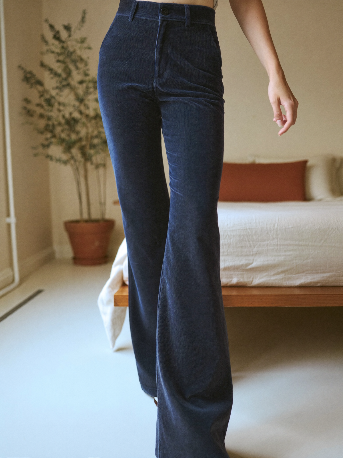 Model wearing dark blue flared trousers, lifestyle