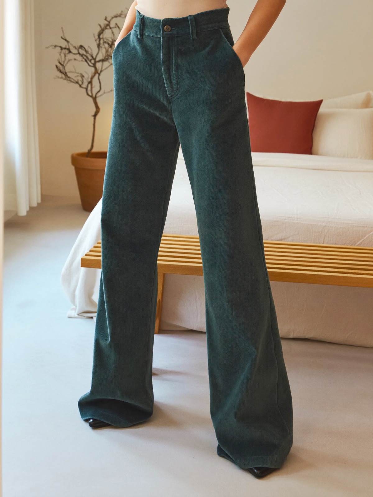 Model wearing dark green flared trousers, lifestyle