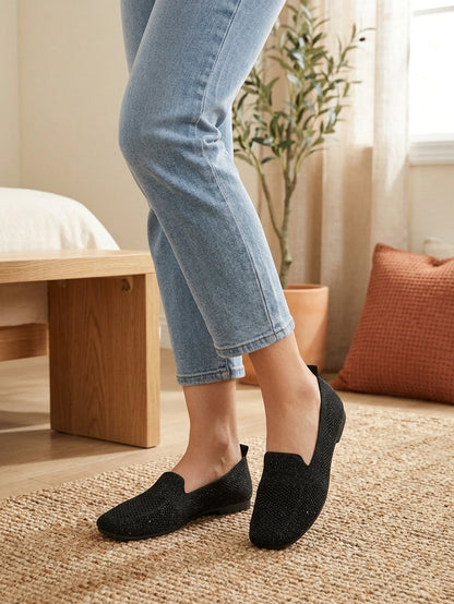 Model wearing black knit slip-on flats