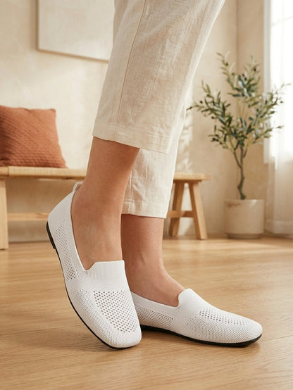 Model wearing white knit slip-on flats