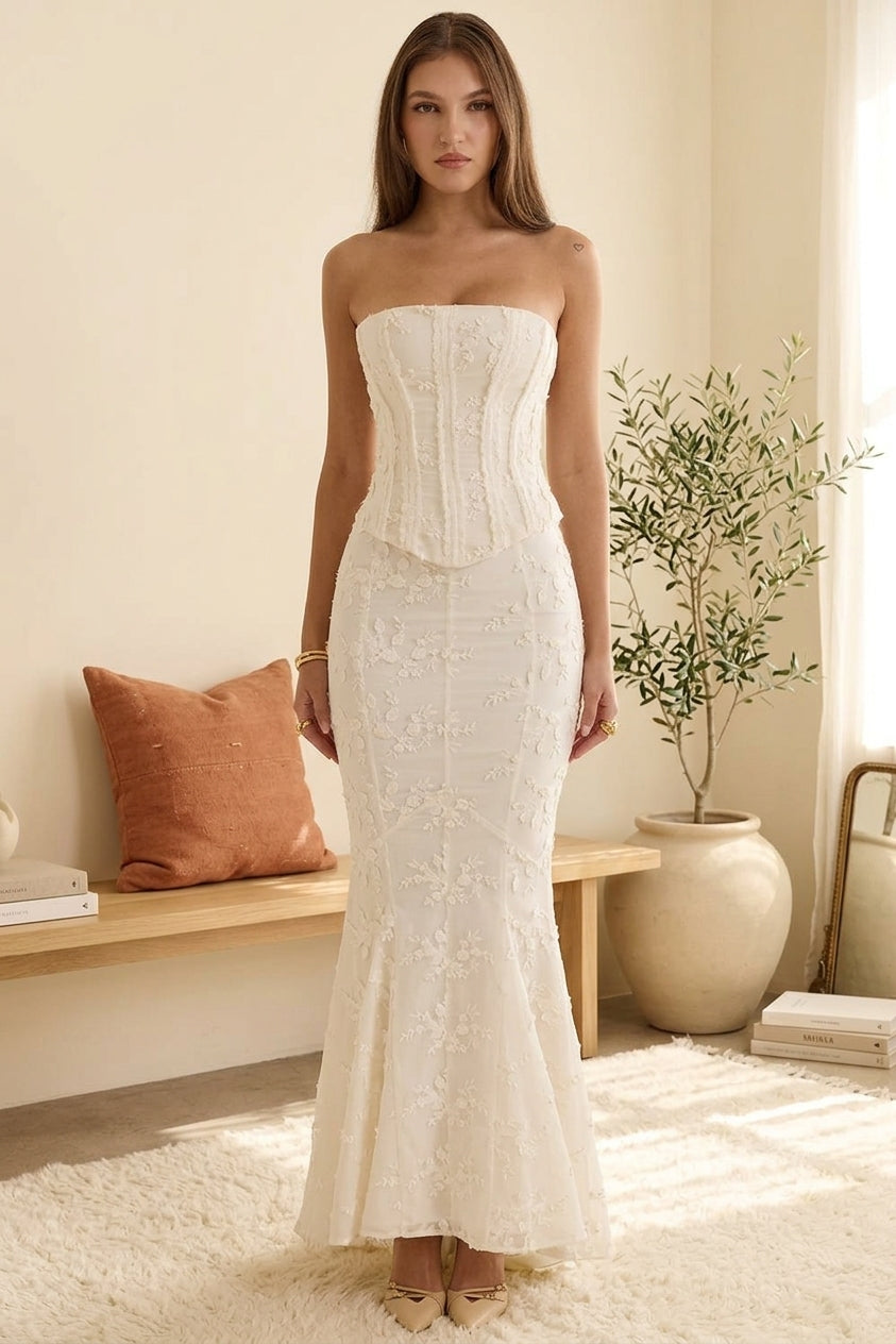 Model wearing white embroidered corset maxi dress