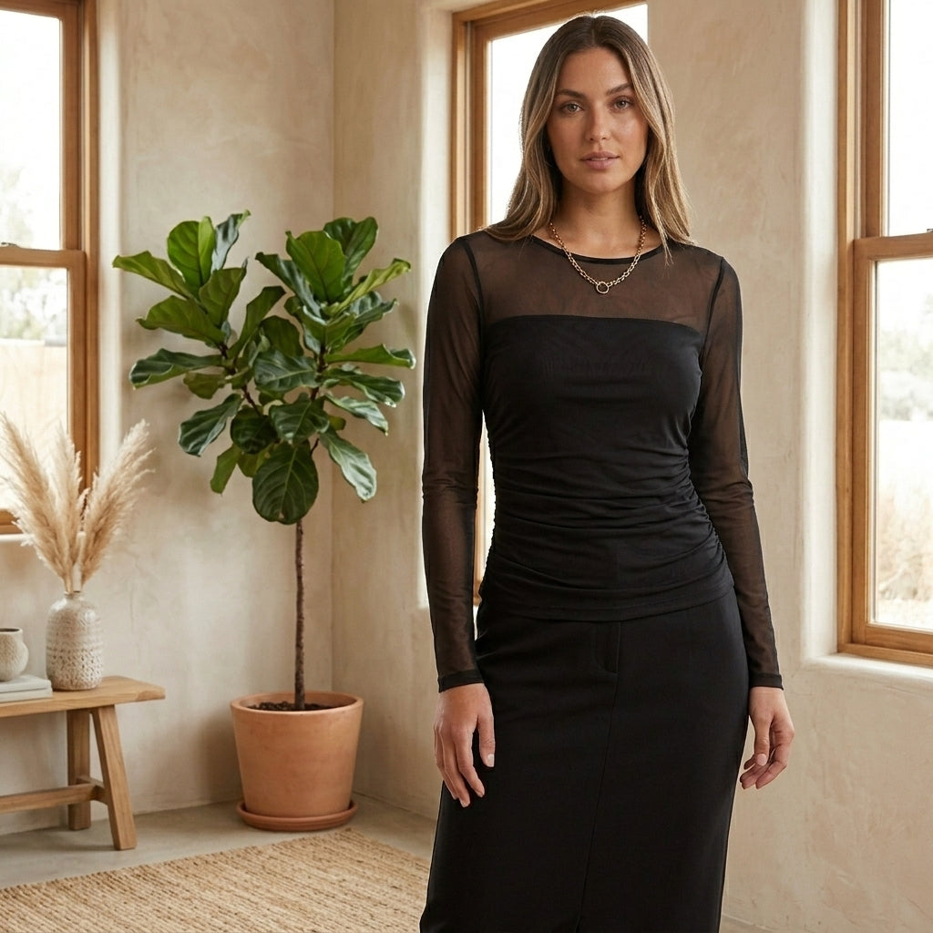 Model wearing black sheer mesh long sleeve top